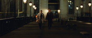 Movie still from “From Paris with Love” (2010), directed by Pierre Morel – A couple of men walking down a sidewalk at night; Wide shot, Low angle