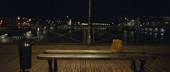 Movie still from “From Paris with Love” (2010), directed by Pierre Morel – A wooden bench on a pier at night; Wide shot, Over the shoulder angle