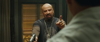 Movie still from “From Paris with Love” (2010), directed by Pierre Morel – A bald man with a gun pointing to his face; Close Up shot, Over the shoulder angle