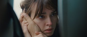 Movie still from “From Paris with Love” (2010), directed by Pierre Morel – A person with her hand near her face; Close Up shot, Over the shoulder angle