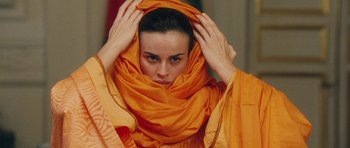 Movie still from “From Paris with Love” (2010), directed by Pierre Morel – A woman in a yellow dress holding her head with her hands; Close Up shot, Low angle
