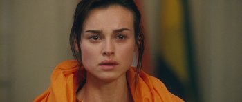 Movie still from “From Paris with Love” (2010), directed by Pierre Morel – A person wearing an orange jacket; Close Up shot, Over the shoulder angle
