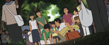 Movie still from “Funan” (2018), directed by Denis Do – A group of people standing around in a forest; Wide shot, High angle