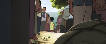 Movie still from “Funan” (2018), directed by Denis Do – A group of people standing on the side of a road; Wide shot, High angle