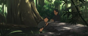 Movie still from “Funan” (2018), directed by Denis Do – Two people in the woods near some trees; Medium shot, High angle