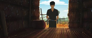 Movie still from “Funan” (2018), directed by Denis Do – An animated man is holding a knife in his hands; Medium shot, Over the shoulder angle