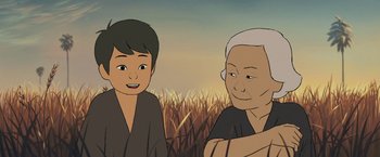 Movie still from “Funan” (2018), directed by Denis Do – Two people standing next to each other near a field; Close Up shot, Over the shoulder angle