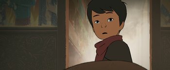 Movie still from “Funan” (2018), directed by Denis Do – A young boy with a red scarf is looking at the camera; Close Up shot, Over the shoulder angle