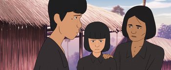 Movie still from “Funan” (2018), directed by Denis Do – Two people standing next to each other in front of a building; Close Up shot, Over the shoulder angle