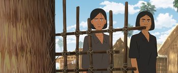 Movie still from “Funan” (2018), directed by Denis Do – An animated woman standing behind a wooden fence; Medium shot, Over the shoulder angle
