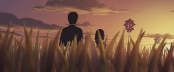 Movie still from “Funan” (2018), directed by Denis Do – Two people standing in tall grass looking out at the sky; Extreme Wide shot, Low angle