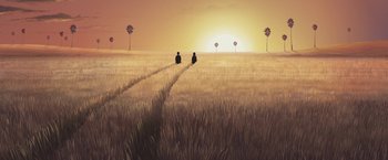Movie still from “Funan” (2018), directed by Denis Do – Two people are walking through a field at sunset; Extreme Wide shot, Low angle