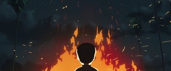 Movie still from “Funan” (2018), directed by Denis Do – A person standing in front of a fire; Extreme Wide shot, Overhead angle