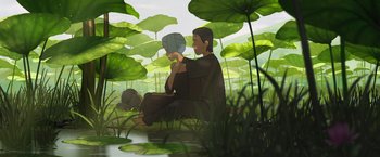 Movie still from “Funan” (2018), directed by Denis Do – An illustration of a man sitting in the grass holding an object; Wide shot, Low angle