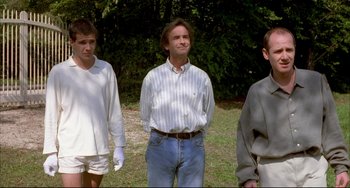 Movie still from “Funny Games” (1997), directed by Michael Haneke – Three men standing in a field with trees in the background; Medium shot, Low angle