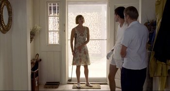 Movie still from “Funny Games” (1997), directed by Michael Haneke – A woman standing next to two men in front of an open door; Wide shot, Low angle