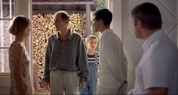 Movie still from “Funny Games” (1997), directed by Michael Haneke – A group of people standing next to each other in a room; Medium shot, Over the shoulder angle