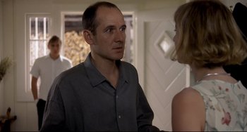 Movie still from “Funny Games” (1997), directed by Michael Haneke – A man and a woman talking to each other; Medium shot, Over the shoulder angle