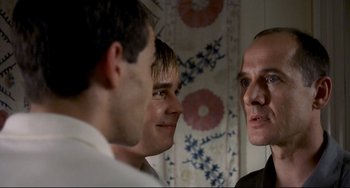 Movie still from “Funny Games” (1997), directed by Michael Haneke – A group of men standing next to each other in a room; Close Up shot, Over the shoulder angle