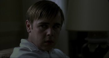 Movie still from “Funny Games” (1997), directed by Michael Haneke – A person wearing a white shirt; Close Up shot, Over the shoulder angle