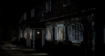 Movie still from “Funny Games” (1997), directed by Michael Haneke – A man is climbing up the side of a house at night; Extreme Wide shot, Low angle