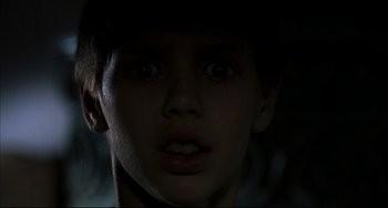 Movie still from “Funny Games” (1997), directed by Michael Haneke – A young boy is looking into the camera; Close Up shot, Low angle