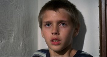 Movie still from “Funny Games” (1997), directed by Michael Haneke – A young boy is looking into the camera; Close Up shot, Low angle
