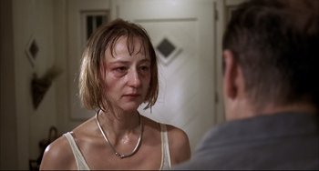 Movie still from “Funny Games” (1997), directed by Michael Haneke – A woman with a bruised eye looking in the mirror; Close Up shot, Over the shoulder angle