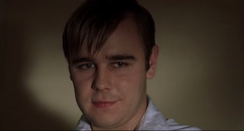 Movie still from “Funny Games” (1997), directed by Michael Haneke – A person wearing a white shirt; Close Up shot, Low angle