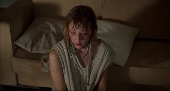 Movie still from “Funny Games” (1997), directed by Michael Haneke – A woman with a stethoscope around her neck; Close Up shot, High angle