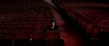 Movie still from “Funny Girl” (1968), directed by William Wyler – A person sitting in a theater with rows of seats; Wide shot, High angle