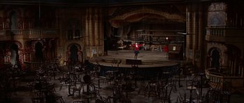 Movie still from “Funny Girl” (1968), directed by William Wyler – A person standing on a stage in a theater; Extreme Wide shot, High angle
