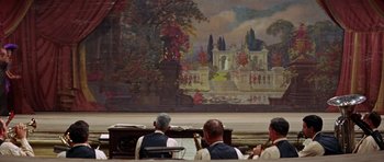 Movie still from “Funny Girl” (1968), directed by William Wyler – A group of people sitting in front of a painting; Extreme Wide shot, Over the shoulder angle
