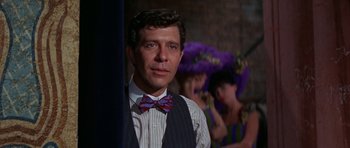 Movie still from “Funny Girl” (1968), directed by William Wyler – A man wearing a striped bow tie and a striped vest; Close Up shot, Over the shoulder angle