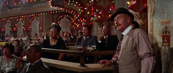 Movie still from “Funny Girl” (1968), directed by William Wyler – A group of men and women sitting at a table; Medium shot, Low angle