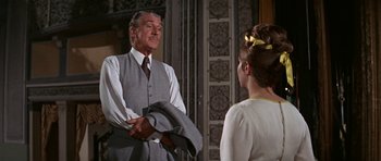 Movie still from “Funny Girl” (1968), directed by William Wyler – An older man wearing a suit and tie talking to a young woman; Medium shot, Over the shoulder angle
