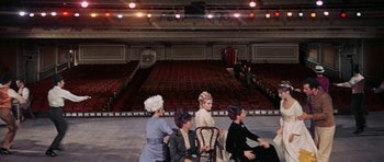 Movie still from “Funny Girl” (1968), directed by William Wyler – A group of women sitting in chairs in front of an auditorium; Extreme Wide shot, High angle