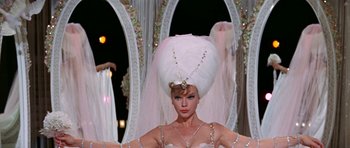 Movie still from “Funny Girl” (1968), directed by William Wyler – A woman in a white dress and a white hat; Medium shot, Low angle