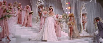Movie still from “Funny Girl” (1968), directed by William Wyler – A group of women dressed in fancy gowns on a stage; Wide shot, Low angle