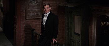 Movie still from “Funny Girl” (1968), directed by William Wyler – A man in a suit standing on a railing; Medium shot, Over the shoulder angle
