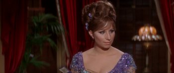 Movie still from “Funny Girl” (1968), directed by William Wyler – A woman in a purple dress with a purple bow in her hair; Close Up shot, Over the shoulder angle