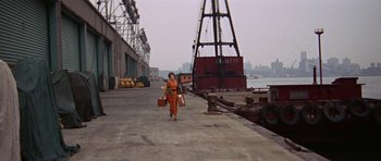 Movie still from “Funny Girl” (1968), directed by William Wyler – A woman in an orange dress carrying two suitcases; Extreme Wide shot, High angle