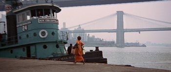 Movie still from “Funny Girl” (1968), directed by William Wyler – A woman in an orange dress is walking by the water; Extreme Wide shot, Low angle