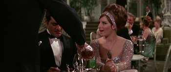 Movie still from “Funny Girl” (1968), directed by William Wyler – A man and woman at a table with a glass of red wine; Medium shot, Over the shoulder angle