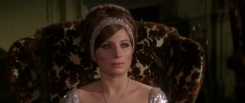 Movie still from “Funny Girl” (1968), directed by William Wyler – A woman in a silver dress sitting in a chair; Close Up shot, Over the shoulder angle