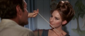 Movie still from “Funny Girl” (1968), directed by William Wyler – A woman holding a string of pearls in front of a man; Close Up shot, Over the shoulder angle