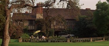 Movie still from “Funny Girl” (1968), directed by William Wyler – People are sitting in the grass outside of a house; Extreme Wide shot, High angle