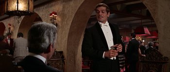 Movie still from “Funny Girl” (1968), directed by William Wyler – A man in a tuxedo talking to another man in a suit; Medium shot, Over the shoulder angle