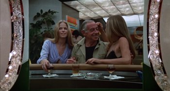 Movie still from “Futureworld” (1976), directed by Richard T. Heffron – Two women and an older man sitting at a bar; Medium shot, Low angle