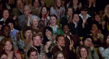 Movie still from “Futureworld” (1976), directed by Richard T. Heffron – A group of people sitting in a room clapping; Medium shot, High angle